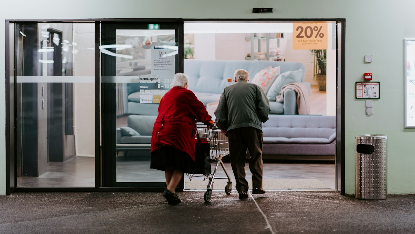 Adultos mayores con andadera entrando a una clínica
